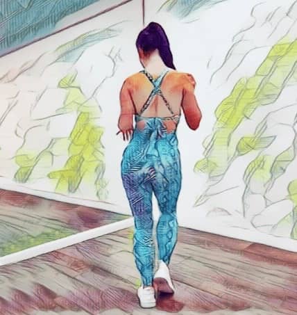 Женщина отрабатывает танцевальные шаги перед зеркалом.